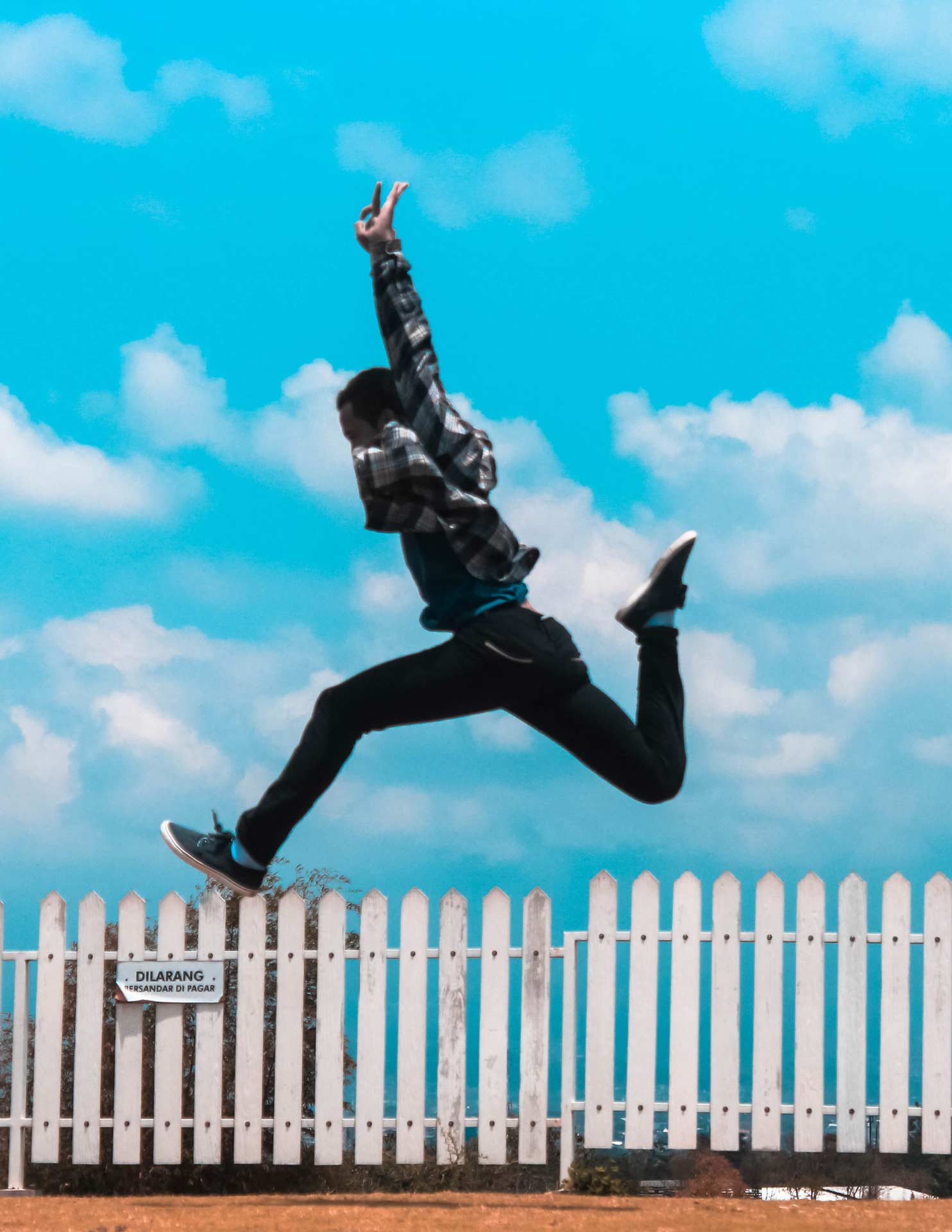 man jumping with bright blue sky in the background